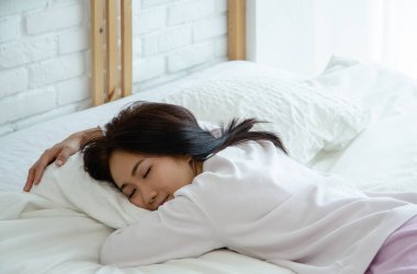 Genç Asyalı kadın yatakta. Uyurken sağlık kavramı