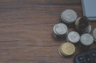 Bozuk paralar ve hesap makinesiyle ahşap masanın yakın çekim görüntüsü