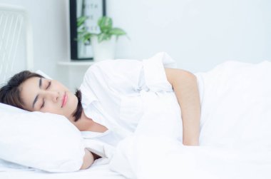 Genç Asyalı kadın yatakta. Uyurken sağlık kavramı