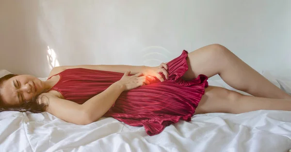 ベッドの上で痛みを持つ病気の女性 — ストック写真