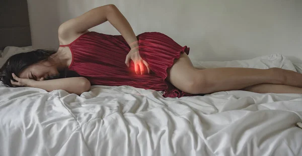 ベッドの上で痛みを持つ病気の女性 — ストック写真