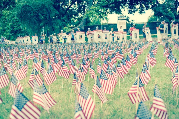 Filtrerte Amerikanske Flagg Med Uklare Rekker Folk Bærer Falne Soldatfaner – stockfoto