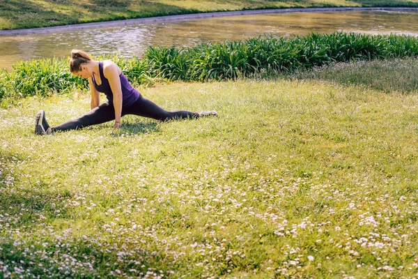 Frau Streckt Beine Auf Dem Rasen Des Parks — Stockfoto