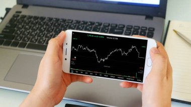 Akıllı telefon ve dizüstü bilgisayarla çalışan iş adamı, hisse senedi alım-satımı konsepti 