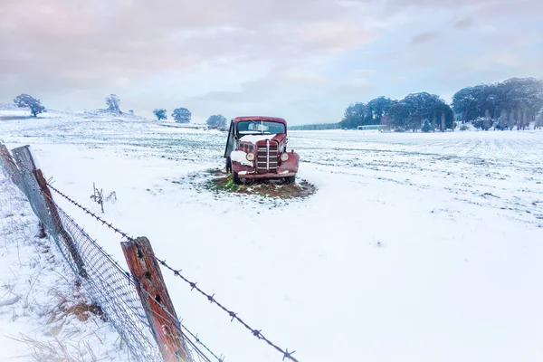 錆びた古い車は 田舎で覆われた雪に座っています — ストック写真