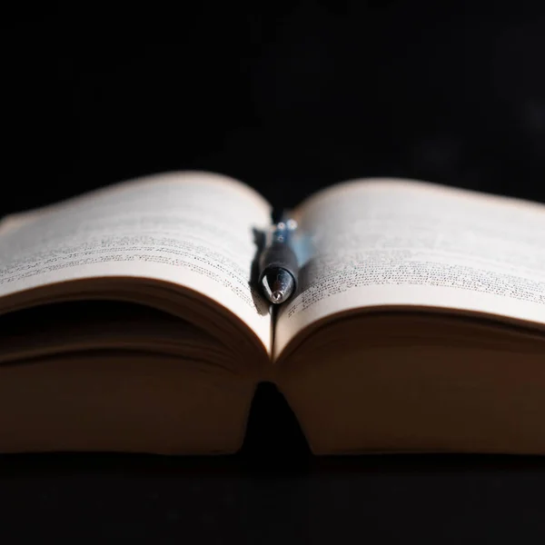 Een Boek Een Pen Zwarte Achtergrond — Stockfoto