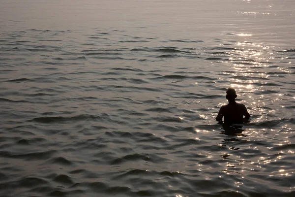 日没の間にガンジス川で風呂に入る男のシルエット — ストック写真
