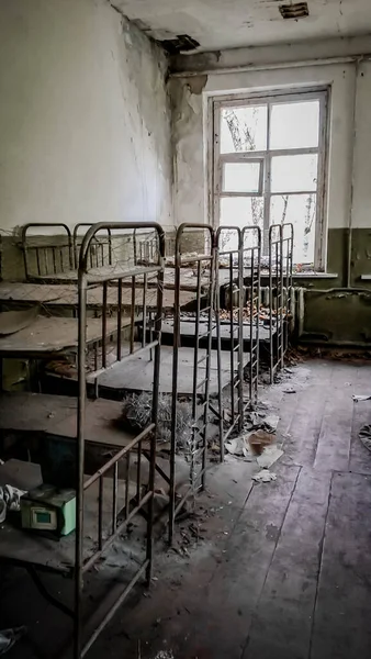 放棄された幼稚園の家の空の子供のベッド — ストック写真