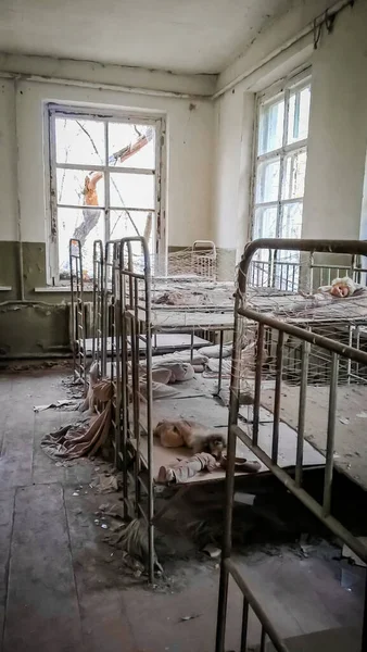 在一间废弃的幼稚园屋的空儿童床 — 图库照片