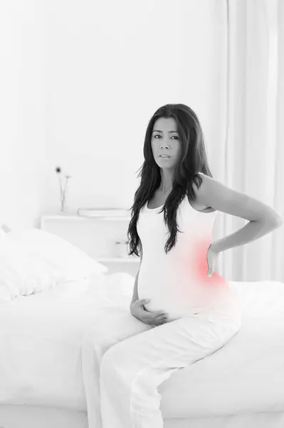 Gut Aussehende Schwangere Hält Sich Sitzen Auf Einem Bett Zurück — Stockfoto