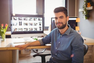 Ofiste oturan mutlu grafik tasarımcısı