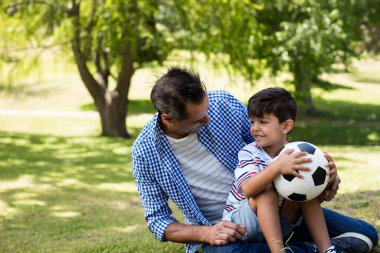 Baba ve oğul parkta birbirleriyle etkileşim halindeler.