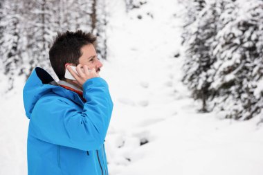 Cep telefonu üzerinde konuşurken kayakçı