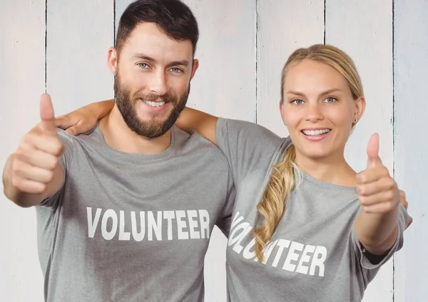 Pareja Voluntarios Sonrientes Pulgar Hacia Arriba Contra Fondo Madera — Foto de Stock