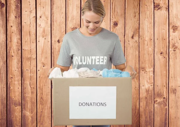 Gelukkig Vrijwilliger Zoek Naar Donatie Doos Tegen Houten Achtergrond — Stockfoto