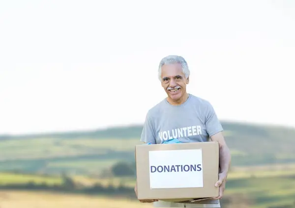 Digital composite of volunteer holding donation box