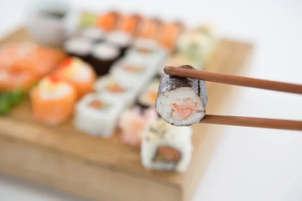 Maki Sushi Being Held Wooden Chopsticks — Stock Photo, Image