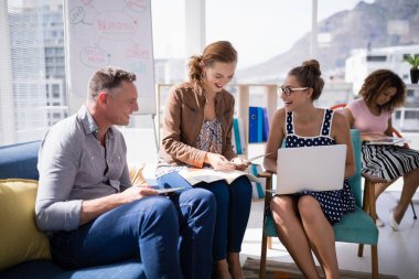 Yöneticilerden oluşan bir ekip birlikte çalışırken birbirleriyle etkileşim halindeler.