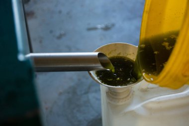 Bir kabın içine zeytinyağı dökülüyor.