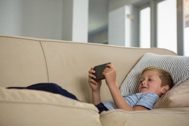 Çocuk cep telefonuyla oturma odasında