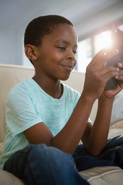 Çocuk cep telefonuyla oturma odasında