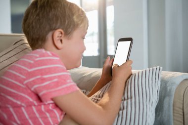 Çocuk cep telefonuyla oturma odasında