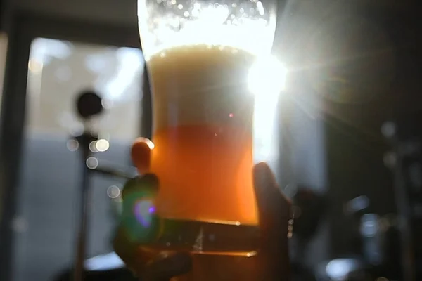 Glass of beer in the hand. Rotation of beer in a glass.