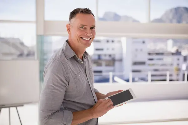 Portrait of happy executive using digital tablet