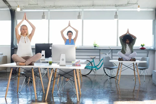 Executives doing yoga in office