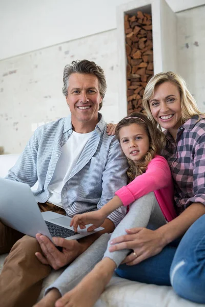 Happy family using laptop together in living room