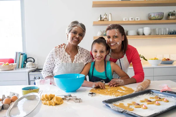 Happy multi-generation family preparing gingerbreads in kitchen