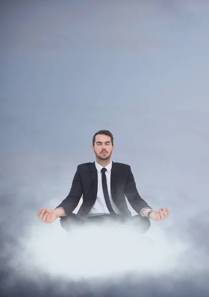 Business man meditating sitting on a cloud