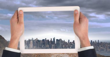 Şehrin üzerinde tablet tutuyor