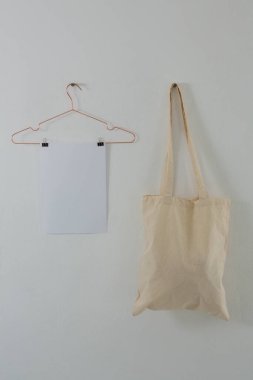 Kağıt ve beyaz duvara asılı çanta