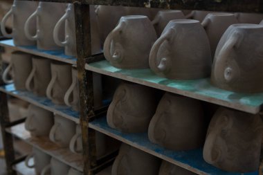 Rafta tutulan toprak tencerelerinin yakın çekim görüntüleri.