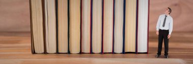 İş adamı kitapların yanına bakıyor.