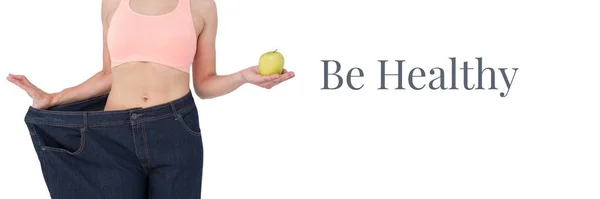 Bądź Zdrowy Tekst Pasuje Kobieta Trzyma Jabłko Ponadgabarytowych Spodniach — Zdjęcie stockowe
