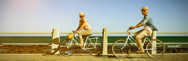 一对快乐的夫妇骑自行车在码头上 — 图库照片