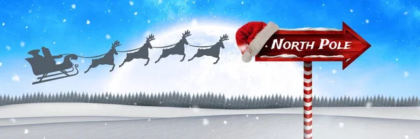 圣诞冬季景观中的木制路标北极文字以及圣诞老人雪橇和驯鹿 — 图库照片#