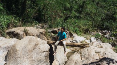 Bir bagajda oturan adam doğanın tadını çıkarıyor.