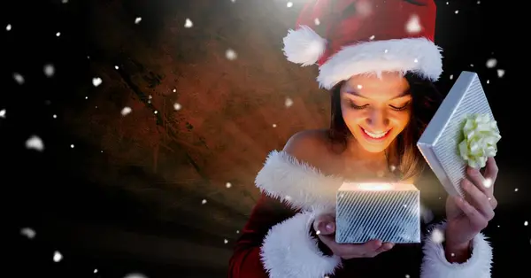 輝く光で魔法のクリスマスギフトボックスを開くエキサイティングなサンタの女性 — ストック写真