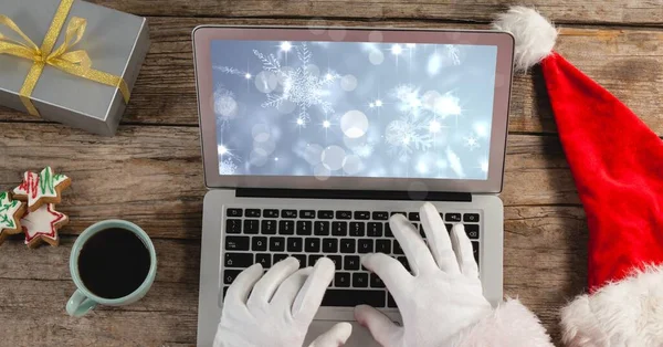 Santa Usando Laptop Com Flocos Neve Mesa Madeira — Fotografia de Stock