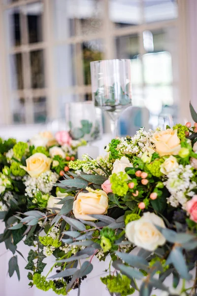 Floral wedding composition with roses and green leaves