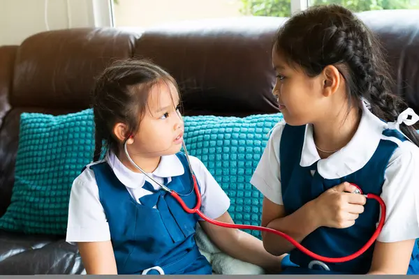 Två Små Flicka Ler Och Leker Läkare Med Stetoskop — Stockfoto