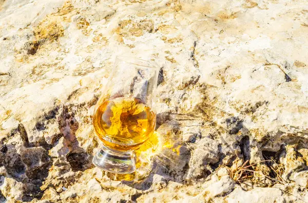 岩の上のガラスにシングルモルトウイスキーのグラス — ストック写真