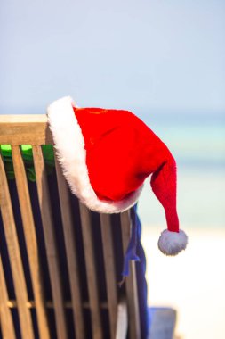 Sandalyedeki Noel Baba şapkası Tropikal sahilde dinleniyor.