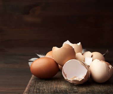 Tahta bir masanın üzerinde kahverengi çiğ tavuk kabuğu, klasik tonlama. 