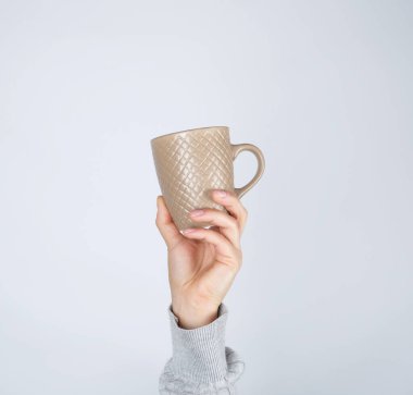 beyaz bir arka planda kadın el kahverengi seramik fincan