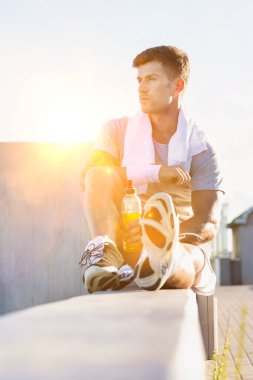 Enerji içeceği içerken oturan çekici genç adamın portresi