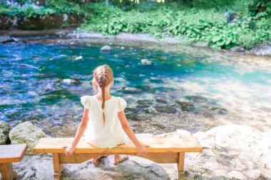 Kız nehrin önünde dinleniyor.